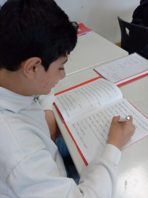 Schüler beim Schreiben eines Textbeitrags für das Buch
